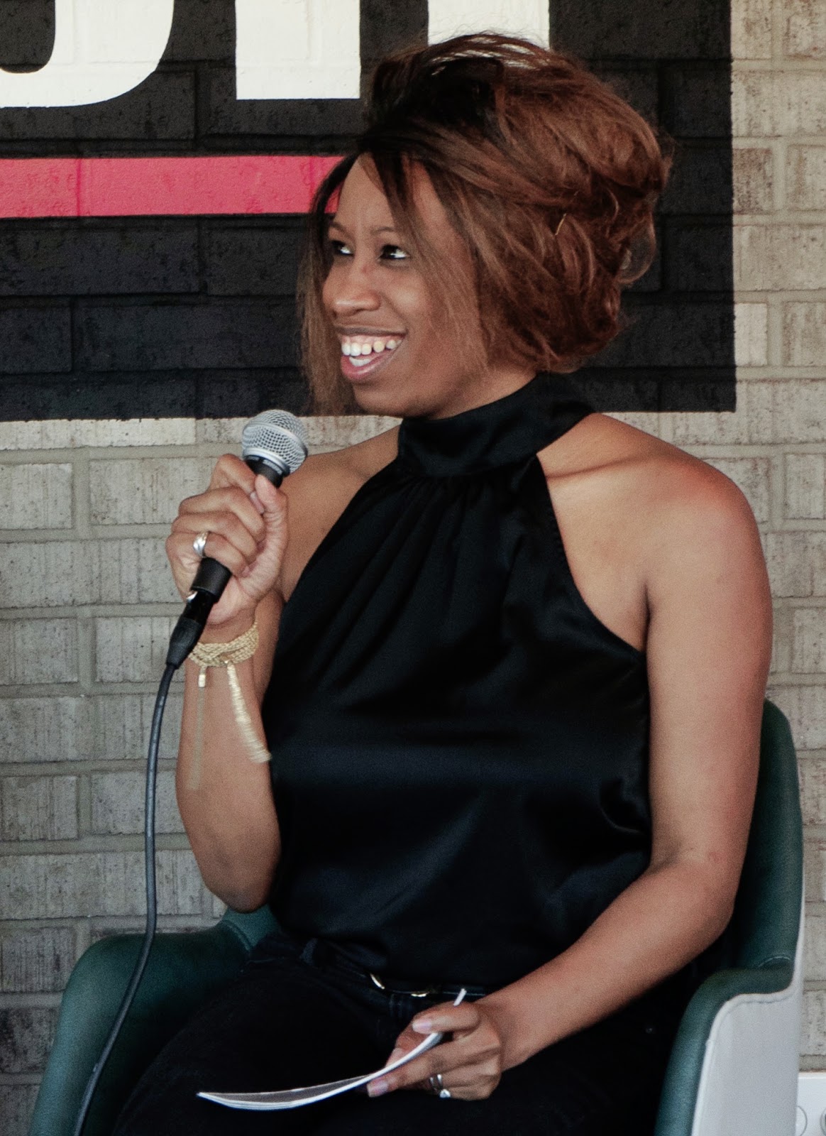 Tia Greene-Granger, host of AHA Moments Podcast, speaking with a microphone
